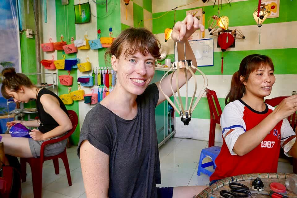 Two people holding a lantern frame in a colourful workshop