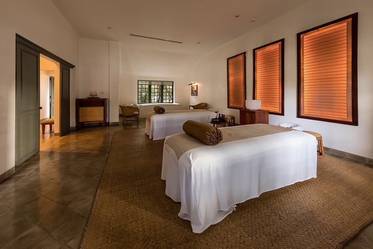 A calm spa treatment room with two massage beds